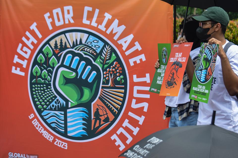 Sejumlah aktivis Organisasi Masyarakat Sipil Untuk Indonesia membentangkan poster saat melakukan aksi di depan Istana Merdeka, Jakarta, Sabtu (9/12/2023). Mereka menuntut pemerintah melakukan perubahan sistem dalam menghadapi ancaman krisis iklim serta so