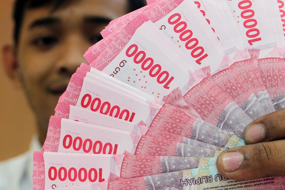 Petugas bank menunjukkan lembaran uang rupiah di salah satu bank di Jakarta, Selasa (12/12/2023). Nilai tukar (kurs) rupiah terhadap dolar AS pada Selasa (12/12) sore menguat tipis sebesar dua poin atau 0,01 persen menjadi Rp15.621 per dolar AS dari Rp15.