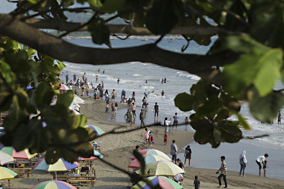 Sejumlah pengunjung bermain di kawasan pantai Citepus, Palabuhanratu, Kabupaten Sukabumi, Jawa Barat, Minggu (24/12/2023). Kawasan ini termasuk hasil pengembangan jasa ekosistem kebudayaan di tingkat daerah.