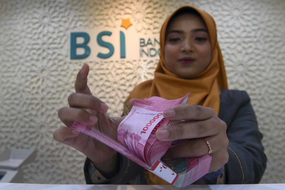 Petugas menghitung uang pecahan rupiah di Kantor Cabang BSI KC Mayestik, Jakarta, Kamis (28/12/2023). Nilai tukar rupiah ditutup di level Rp15.418 per dolar AS pada Kamis (28/12), dimana mata uang Garuda menguat 12 poin atau naik 0,08 persen dari penutupa