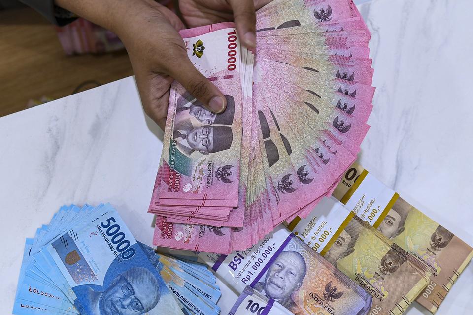 Petugas menyusun uang pecahan rupiah di Kantor Cabang BSI KC Mayestik, Jakarta, Kamis (28/12/2023). Nilai tukar rupiah ditutup di level Rp15.418 per dolar AS pada Kamis (28/12), dimana mata uang Garuda menguat 12 poin atau naik 0,08 persen dari penutupan 