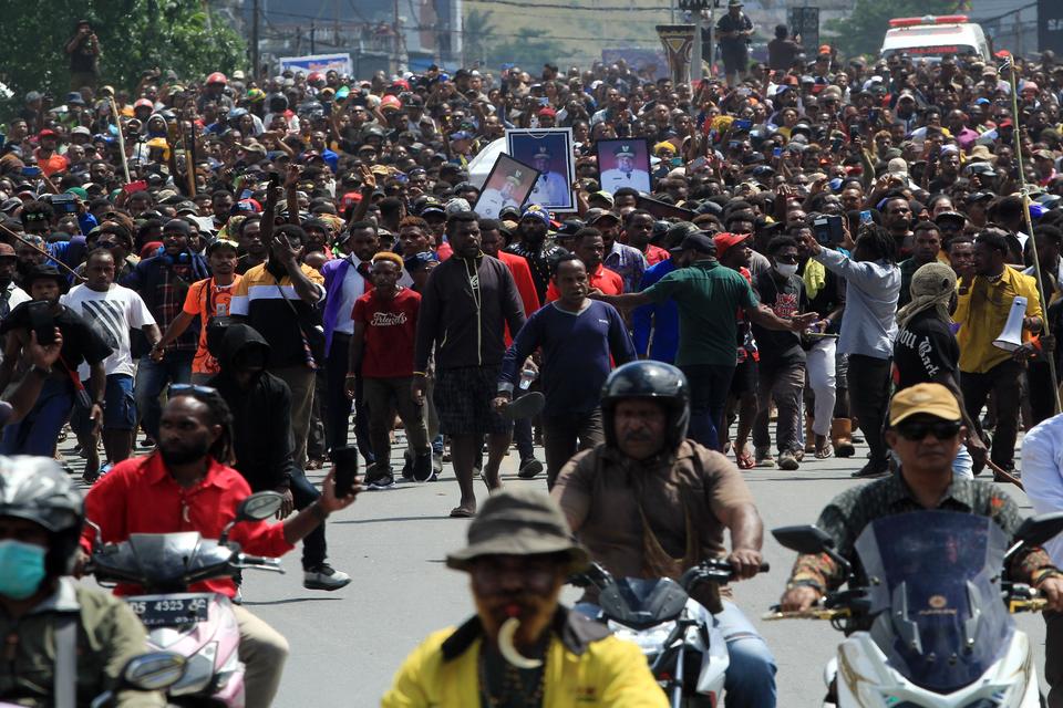 Arak-arakan warga saat membawa peti jenazah mantan Gubernur Papua Lukas Enembe ke tempat persemayaman di Koya Tenga, Kota Jayapura, Papua, Kamis (28/12/2023). 