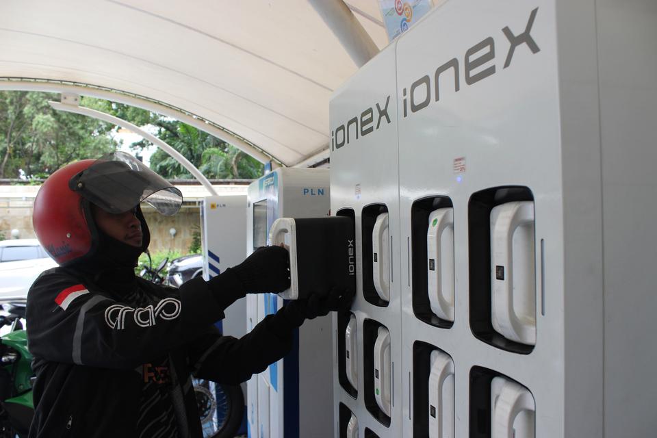 Seorang pengemudi menukar baterai motor listrik di Stasiun Penukaran Baterai Kendaraan Listrik Umum (SPBKLU) Gambir, Jakarta, Selasa (2/1/2024).