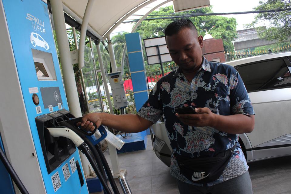 Seorang warga mengisi daya mobil listrik di Stasiun Pengisian Kendaraan Listrik Umum (SPKLU) Gambir, Jakarta, Selasa (2/1/2024). PLN mencatat hingga akhir 2023 terdapat sekitar 1.000 lebih SPKLU di seluruh Indonesia yang 60 persen di antaranya dimiliki PL