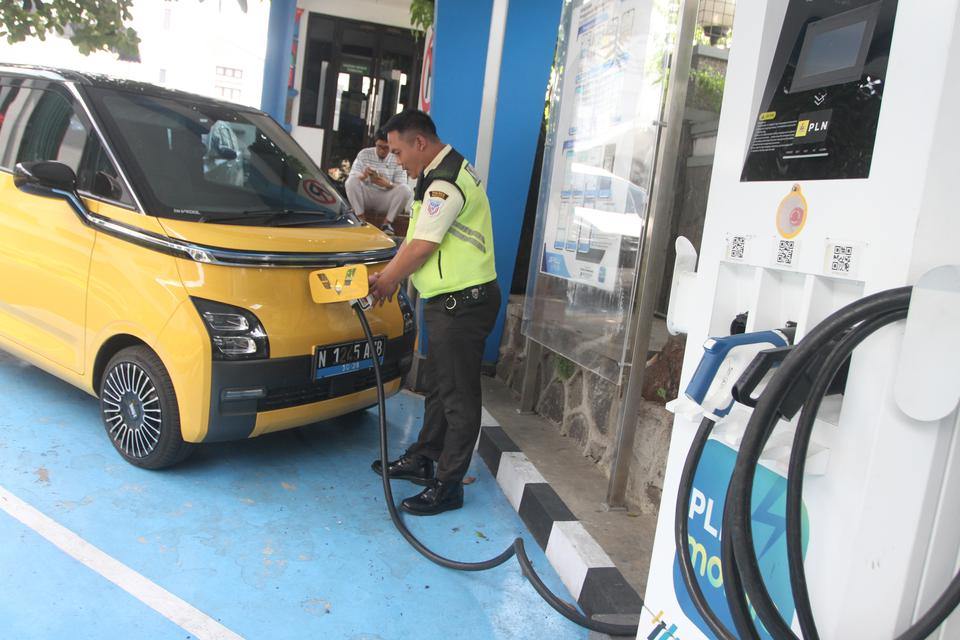 Seorang petugas membantu pengisian ulang mobil listrik milik konsumen di Stasiun Pengisian Kendaraan Listrik Umum (SPKLU) PLN UP3 Kota Malang, Jawa Timur, Rabu (3/1/2024). PT PLN Unit Induk Distribusi (UID) Jatim mencatat hingga akhir tahun 2023 terdapat 