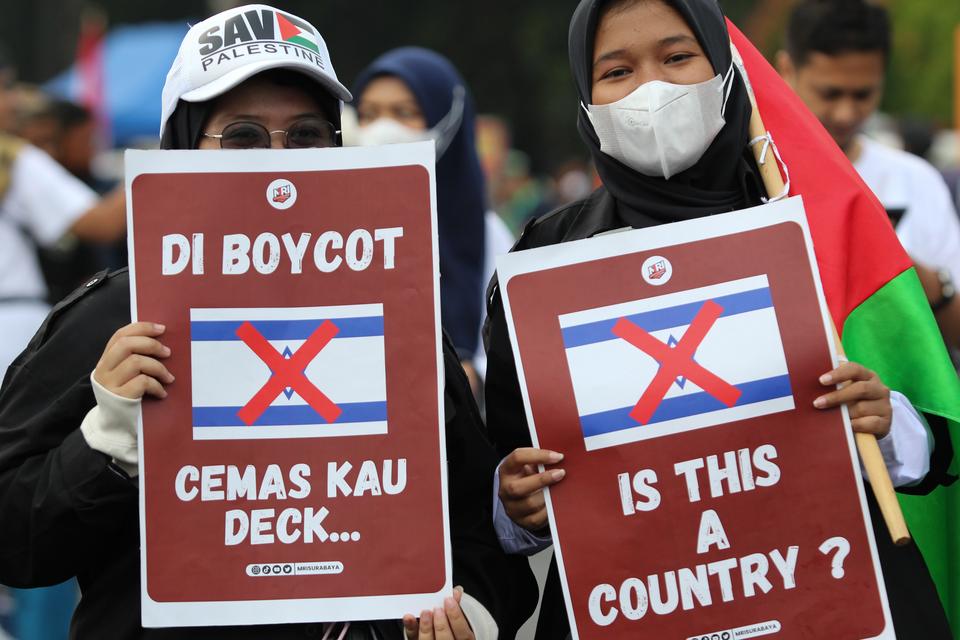Warga membentangkan poster saat mengikuti Munajat Kemerdekaan Palestina di Surabaya, Jawa Timur, Minggu (7/1/2024). Kegiatan yang dihadiri ratusan orang yang digelar oleh Aliansi Rakyat Bela Palestina tersebut dilakukan sebagai bentuk solidaritas dan kepe