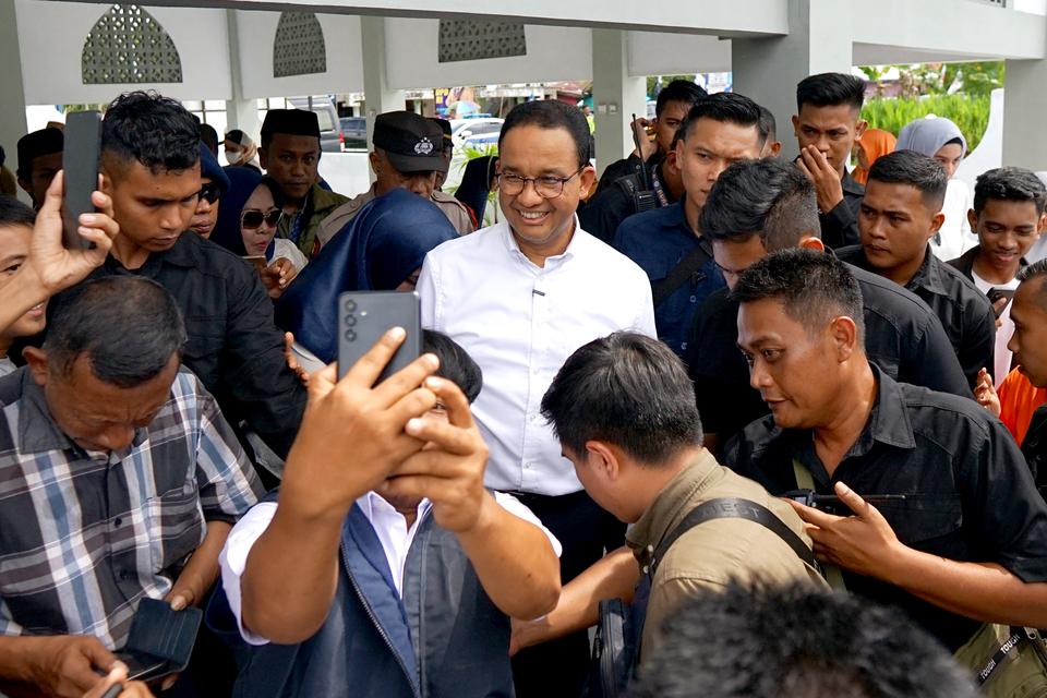 Calon presiden nomor urut satu Anies Baswedan (tengah) menyapa warga usai menabur bunga di makam pahlawan Gorontalo dan nasional Nani Wartabone di Suwawa, Kabupaten Bone Bolango, Gorontalo, Senin (8/1/2024).