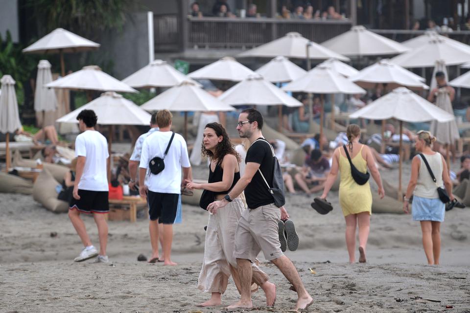 Wisatawan mancanegara (wisman) berwisata mengunjungi kawasan Pantai Batu Bolong di Badung, Bali, Senin (8/1/2024). Kementerian Pariwisata dan Ekonomi Kreatif menargetkan 9,5 juta -14,3 juta kunjungan wisman ke Indonesia sepanjang tahun 2024.