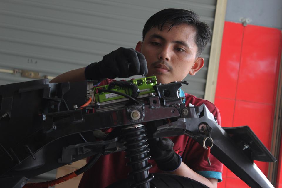 Seorang teknisi memasang komponen motor listrik sebagai bagian dari proses konversi di bengkel konversi Bintang Racing Team, Kabupaten Bogor, Jawa Barat, Jumat (12/1/2024). Pemerintah menaikan subsidi konversi motor listrik dari yang sebelumnya Rp7 juta m