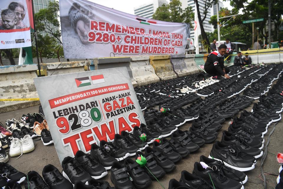 Seorang pengunjuk rasa meletakkan sepatu yang menyimbolkan tewasnya ribuan anak di Gaza saat aksi bela Palestina di depan Kedubes Amerika Serikat, Jakarta, Senin (15/1/2024). Dalam aksinya, mereka menyerukan dihentikannya serangan Israel kepada warga Pale
