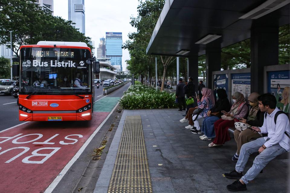 Sejumlah warga menunggu kedatangan bus listrik Transjakarta di kawasan Sudirman, Jakarta, Selasa (16/1/2024). PT Transportasi Jakarta menargetkan akan menambah sebanyak 200 bus listrik secara bertahap di tahun 2024 sebagai komitmen Transjakarta untuk meny