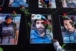 Warga menaruh bunga mawar di atas sejumlah foto jurnalis peliput konflik Israel-Hamas di Gaza, Palestina pada aksi damai di Solo, Jawa Tengah, Minggu 