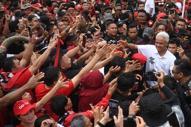 Calon presiden nomor urut 3 Ganjar Pranowo (kanan) menyalami pendukungnya saat kampanye bertajuk Hajatan Rakyat di Manado, Sulawesi Utara, Kamis (1/2/2024). Dalam kampanye yang diikuti ribuan simpatisan tersebut, Ganjar menyerukan kepada pendukungnya untu