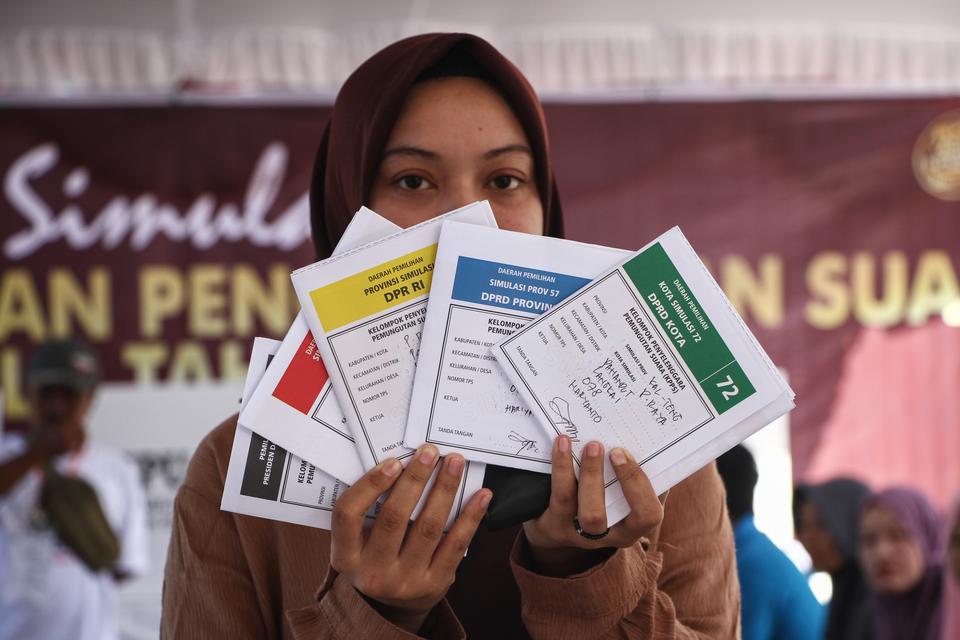 Warga menunjukkan surat suara pemilu 2024 saat simulasi pemungutan dan penghitungan suara di tempat pemungutan suara (TPS), Taman Pasuk Kameloh, Palangka Raya, Kalimantan Tengah, Jumat (2/2/2024). KPU Kota Palangka Raya menggelar simulasi untuk memberikan