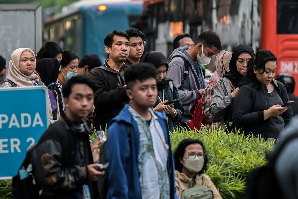 Sejumlah pekerja menunggu angkutan umum di Jalan Sudirman, Jakarta, Selasa (6/2/2024). 
