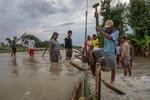 Gotong royong membuat tanggul darurat untuk menahan banjir di Demak