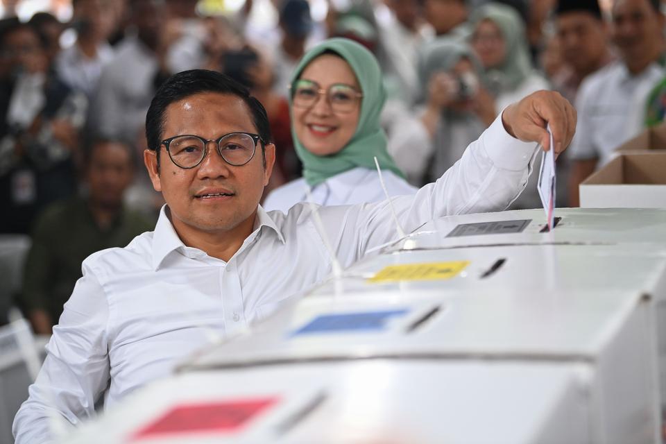 Calon wakil presiden nomor urut 1 Muhaimin Iskandar (kiri) bersama istrinya, Rustini Murtadho (kanan) memasukkan surat suara yang telah mereka coblos ke dalam kotak suara di TPS 023 Kelurahan Bangka, Mampang, Jakarta, Rabu (14/2/2024). Pemilu 2024 yang di