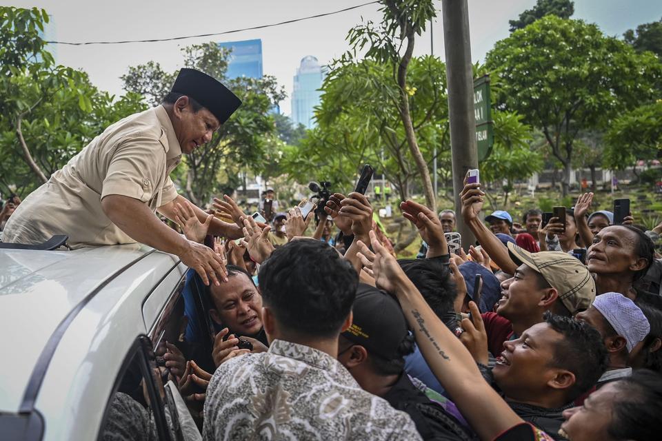 Calon presiden nomor urut 2 Prabowo Subianto menyapa warga usai berziarah ke makam ayahnya Soemitro Djojohadikusumo di TPU Karet Bivak, Jakarta, Kamis (15/2/2024). Prabowo juga berziarah ke makam ibunya Dora Marie Sigar di TPU Tanah Kusir.