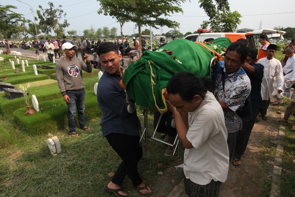 Warga menggotong jenazah Joko Budiono (51) untuk dimakamkan di Tempat Pemakaman Umum (TPU) Keputih, Surabaya, Jawa Timur, Jumat (16/2/2024). Joko Budiono (51) yang merupakan Ketua Kelompok Penyelenggara Pemungutan Suara (KPPS) di Tempat Pemungutan Suara (