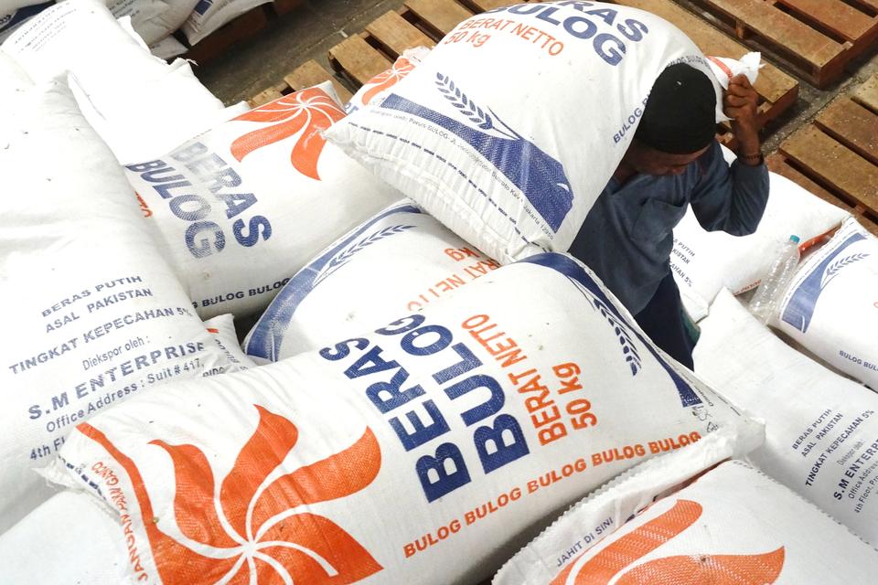 Pekerja mengangkut beras Bulog untuk dikemas ulang ukuran 5 kg beras di gudang Bulog Mojongapit, Kabupaten Jombang, Jawa Timur, Rabu (21/2/2024). Perum Bulog Sub Divre Wilayah Surabaya Selatan memastikan stok beras stabilisasi pasokan dan harga pangan (SP