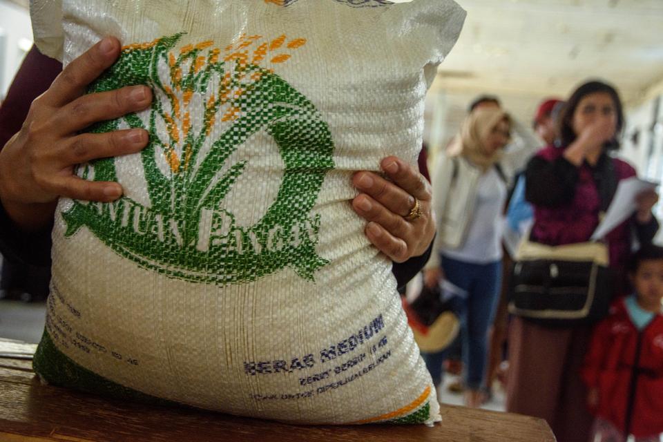 Warga penerima manfaat mengambil beras saat penyaluran bantuan sosial (Bansos) pangan cadangan beras pemerintah di Kantor Pos Bandung, Jawa Barat, Kamis (29/2/2024). 