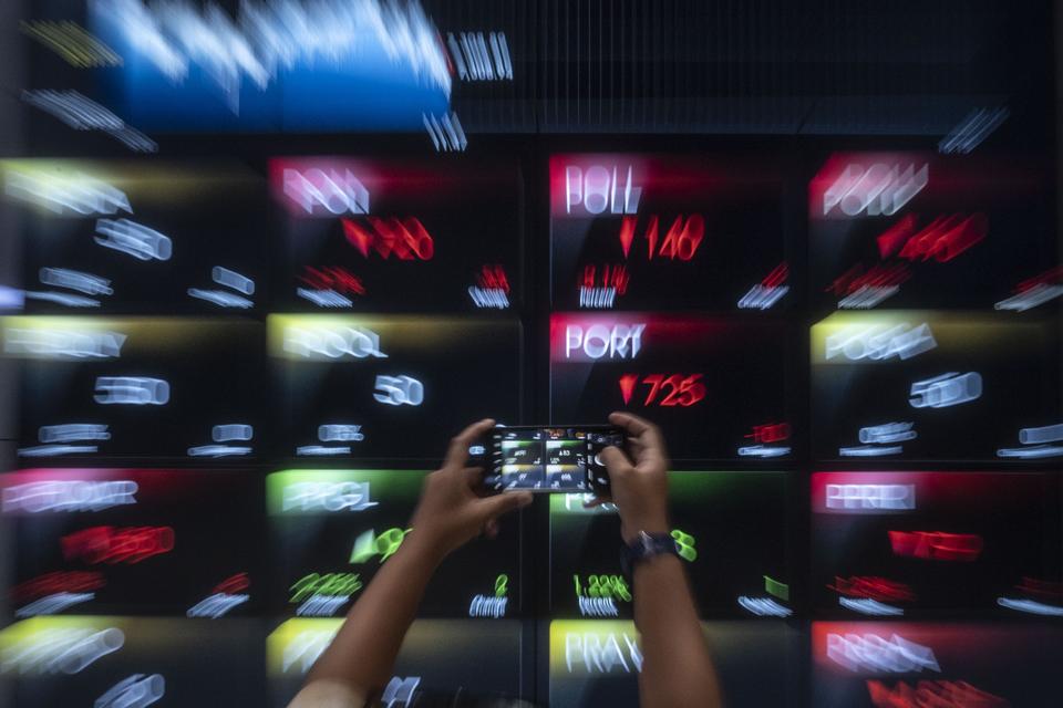 Seorang karyawan memotret layar digital yang menampilkan pergerakan Indeks Harga Saham Gabungan (IHSG) di Bursa Efek Indonesia (BEI), Jakarta, Senin (4/3/2024). IHSG ditutup melemah 35,16 poin atau 0,48 persen ke level 7.276,75.
