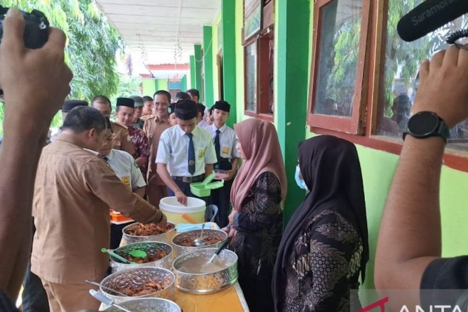 Pj Bupati Aceh Besar Muhammad Iswanto menaruh lauk pauk kepada siswa SMPN I Darul Imarah di sela-sela meluncurkan simulasi makan siang gratis bergizi di Darul Imarah, Selasa (6/3/2024).