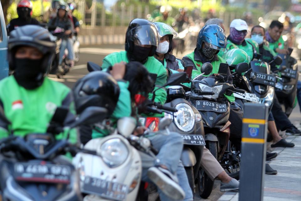 Sejumlah pengemudi  ojek daring menunggu penumpang di Jalan Raya Margonda, Kota Depok, Jawa Barat, Rabu (20/3/2024). Kementerian Ketenagakerjaan (Kemnaker) mengimbau agar perusahaan transportasi online memberikan Tunjangan Hari Raya (THR) kepada mitra dri