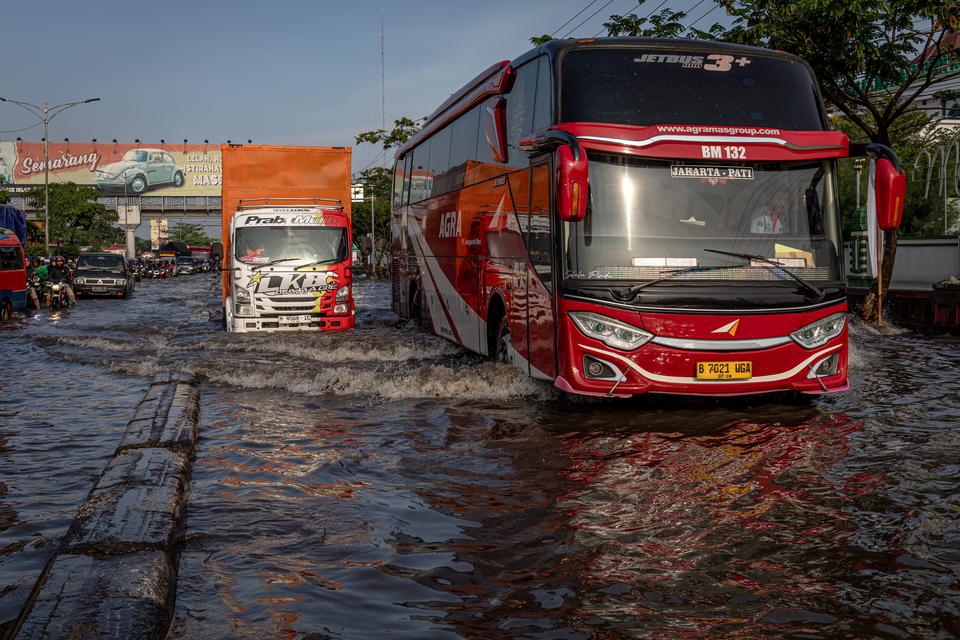 Sebuah bus dari Jakarta menuju Pati menembus banjir yang menggenangi jalur utama pantura Semarang-Surabaya di Jalan Kaligawe Raya, Kota Semarang, Jawa Tengah, Sabtu (6/4/2024). Pada H-4 Lebaran atau Sabtu (6/4), jalan utama pemudik yang melalui jalur ter
