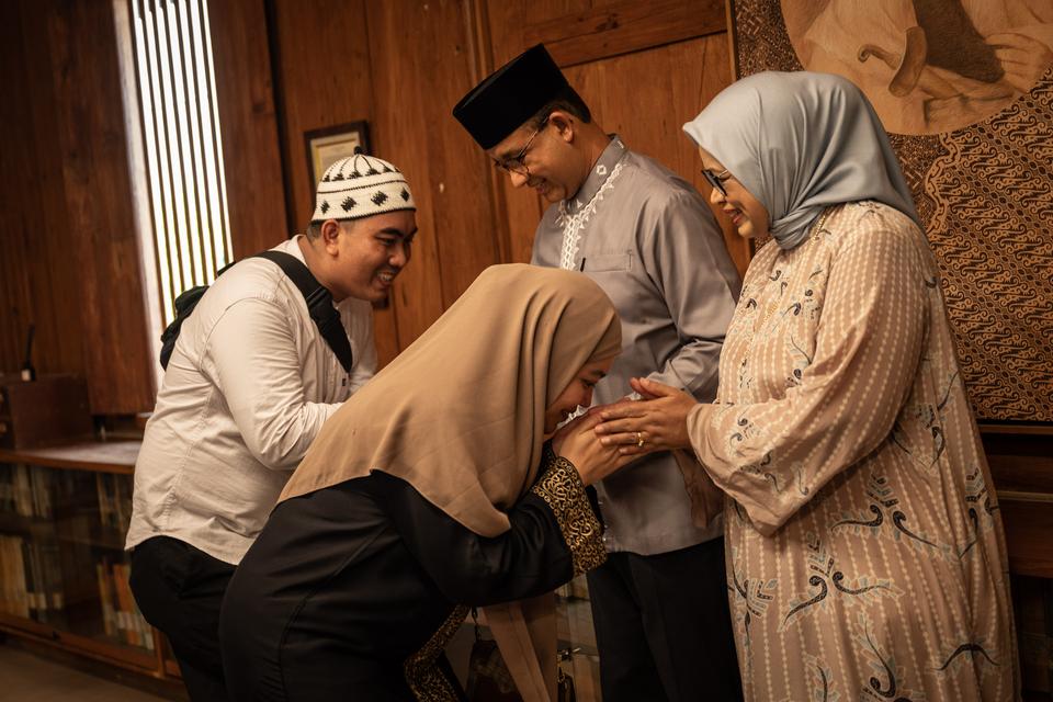 Anies Baswedan (dua kanan) didampingi istri Fery Farhati (kanan) menyalami warga yang datang saat open house di Pendopo Kediaman Anies Baswedan, Jakarta, Rabu (10/4/2024). 