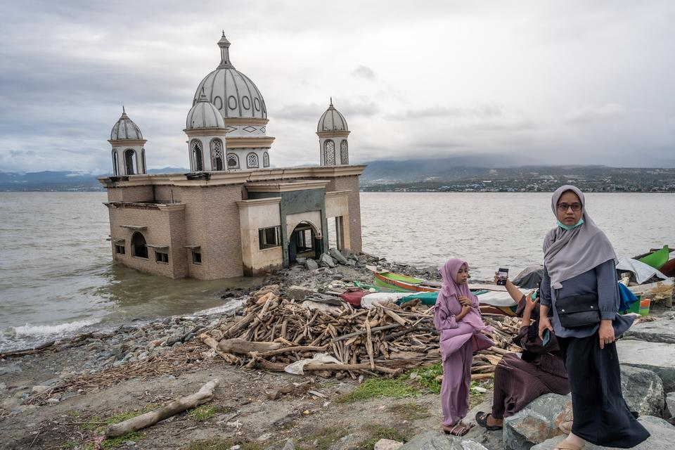 Pengunjung berada di dekat masjid terapung Arqam Baburrahman yang amblas ke laut akibat tsunami di Pantai Kampung Lere, Palu, Sulawesi Tengah, Kamis (11/4/2024). Kawasan itu menjadi salah satu tujuan favorit wisata bagi pengunjung terutama dari luar Kota 