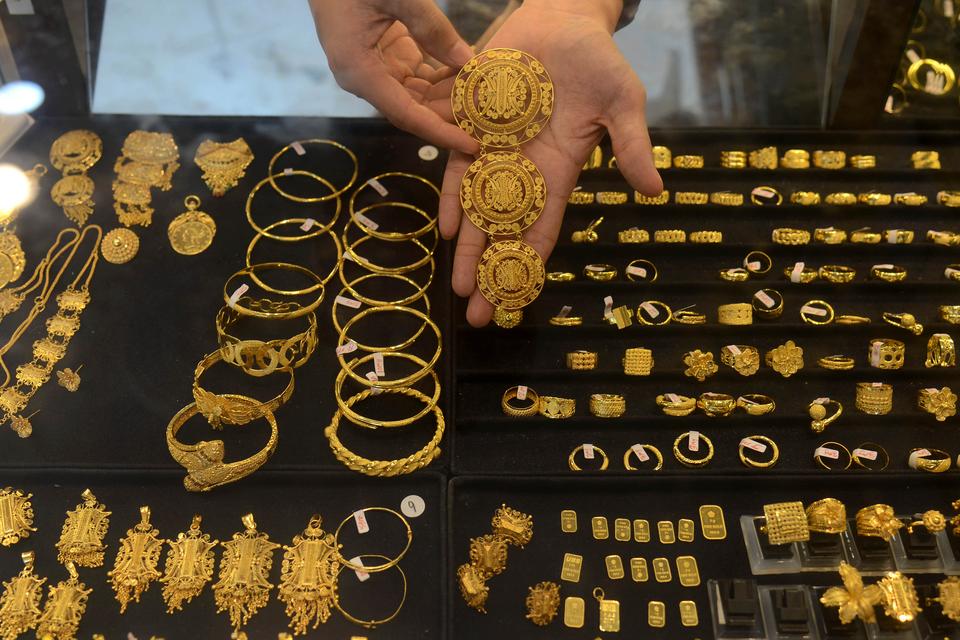 Pedagang memperlihatkan berbagai jenis perhiasan emas kepada calon pembeli di pusat perdagangan logam mulia Pasar Aceh, Banda Aceh, Kamis (18/4/2024). Menurut pedagang, meskipun harga emas Antam cenderung menguat dan berada pada level Rp1.330.000 per g