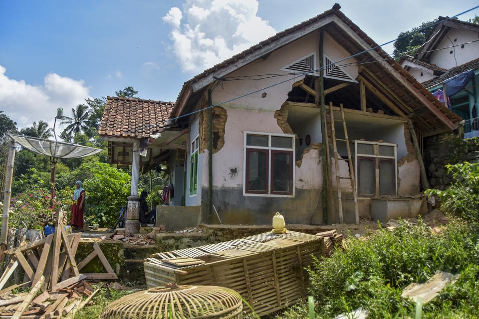 Warga membersihkan puing bangunan rumahnya yang roboh terdampak gempa di Desa Sukamulya, Ciamis, Jawa Barat, Minggu (28/4/2024). 