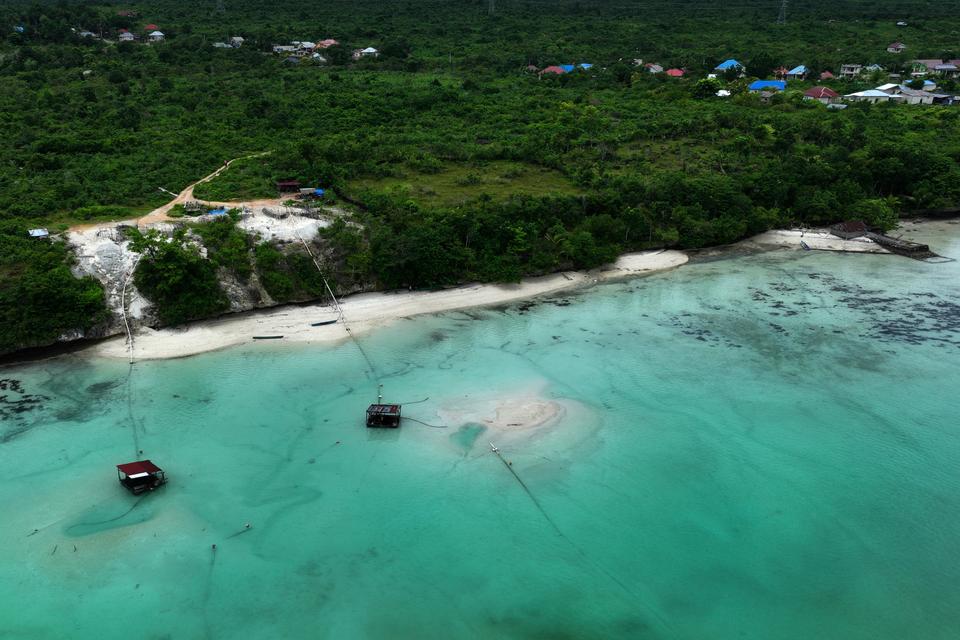 Foto udara dua mesin pengisap menarik pasir laut di perairan lombe di Desa Wakeakea, Buton Tengah, Sulawesi Tenggara, Selasa (30/4/2024). 