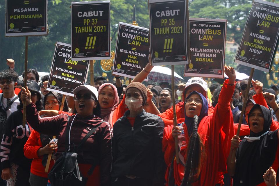 Pengunjukrasa membawa poster saat aksi memperingati Hari Buruh Sedunia di depan Balaikota Malang, Jawa Timur, Rabu (1/5/2024). 