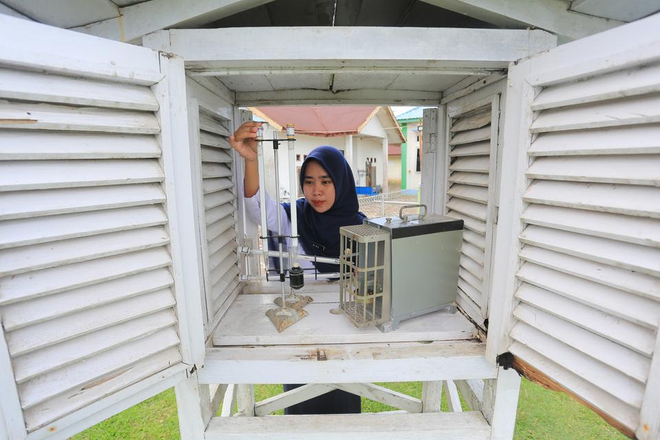 Petugas melakukan pengecekkan suhu melalui sangkar meteorologi di Laboratorium Badan Meteorologi Klimatologi dan Geofisika (BMKG) Stasiun Meteorologi Cut Nyak Dien Meulaboh Nagan Raya, Kecamatan Kuala Pesisir, Nagan Raya, Aceh, Senin (13/5/2024). BMKG men