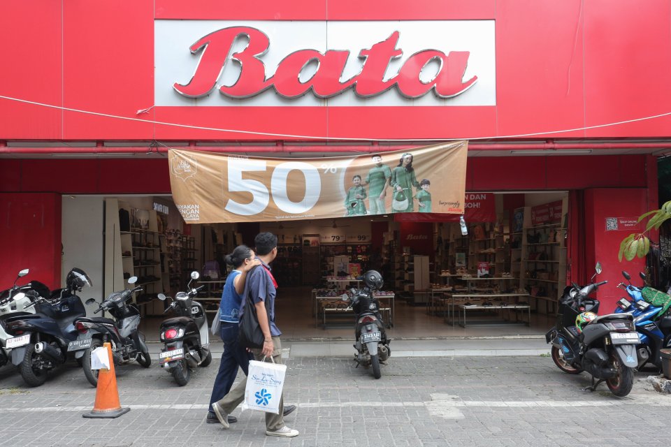 Dua orang warga melintas di depan Toko Sepatu Bata di Pasar Baru, Jakarta, Senin (13/5/2024). 