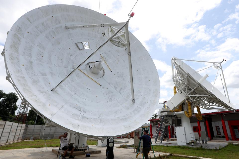 Pekerja menyelesaikan pembangunan antena satelit komunikasi stasiun bumi Pasifik Satelit Nusantara (PSN) di Aceh Besar, Aceh, Minggu (19/5/2024). 