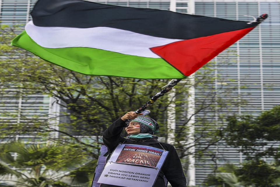 Seorang pengunjuk rasa dari Koalisi Indonesia Bela Baitul Maqdis (KIBBM) mengibarkan bendera Palestina saat mengikuti aksi bela Palestina di depan Kedutaan Besar Amerika Serikat, Jalan Medan Merdeka Selatan, Jakarta, Sabtu (1/6/2024). 