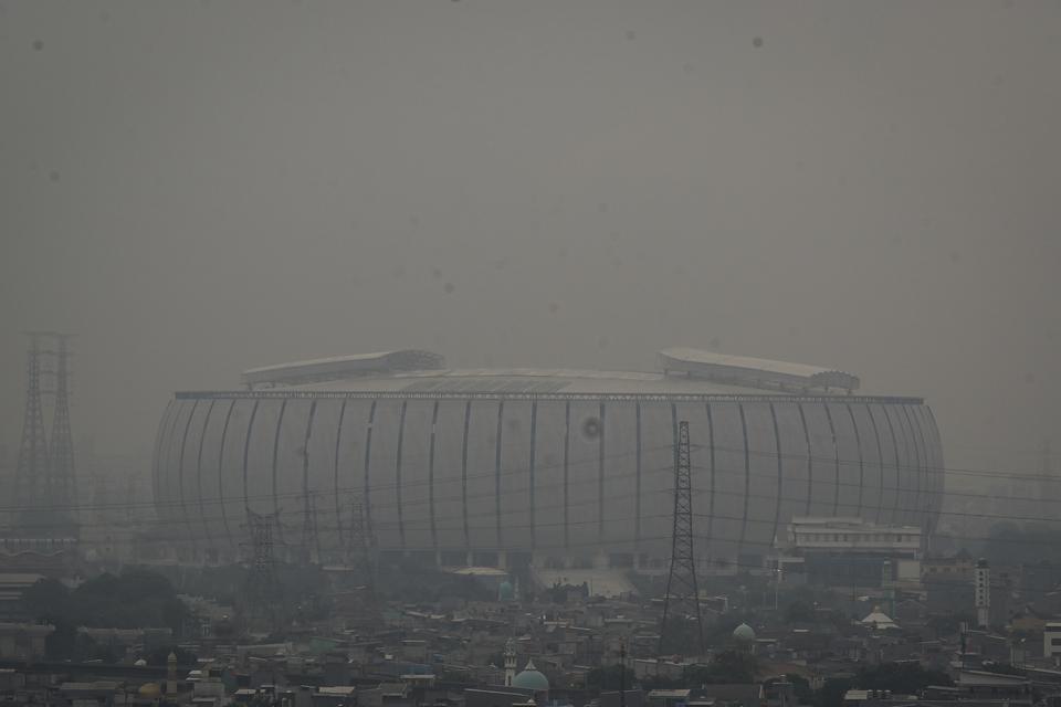 Suasana polusi udara yang menyelimuti bangunan Jakarta International Stadium (JIS), Jakarta Utara, Jakarta, Sabtu (15/6/2024). Berdasarkan data IQAir pukul 05.00 WIB mencatat kualitas udara Jakarta berada pada poin 106 dengan tingkat konsentrasi polutan P