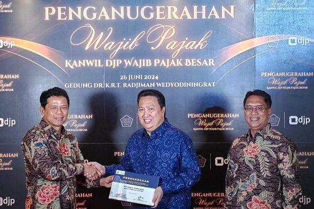 Presiden Direktur PT Adaro Energy Indonesia Tbk Garibaldi Thohir (tengah) menerima penghargaan dari Kepala Kantor Wilayah DJP Wajib Pajak Besar Yunirwansyah (kiri)