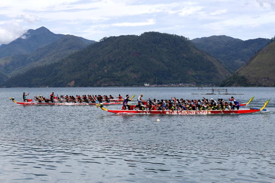 Peserta lomba dayung tradisional perahu naga saling memacu kecepatan di danau laut tawar, Aceh Tengah, Aceh, Minggu (30/6/2024). Lomba yang diikuti pemuda dari berbagai desa di sekitar danau laut tawar itu bertujuan untuk menarik minat dan menambah target