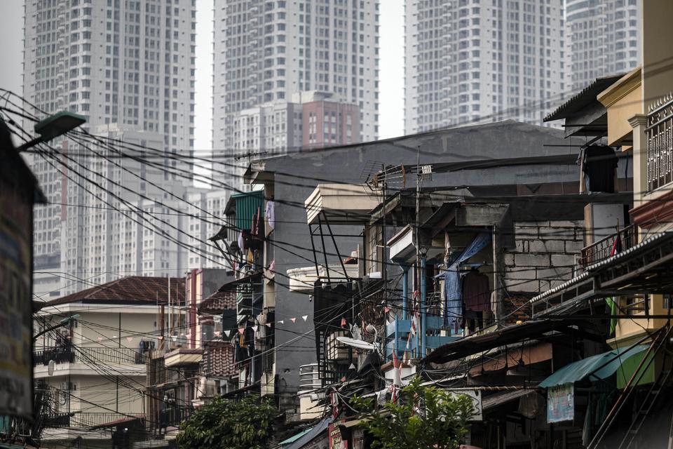 Deretan permukiman penduduk dengan latar belakang apartemen di kawasan Muara Angke, Jakarta, Senin (1/7/2024). Badan Pusat Statistik (BPS) mencatat angka penduduk miskin pada Maret 2024 mengalami penurunan sebesar 0,33 persen menjadi 9,03 persen bila diba