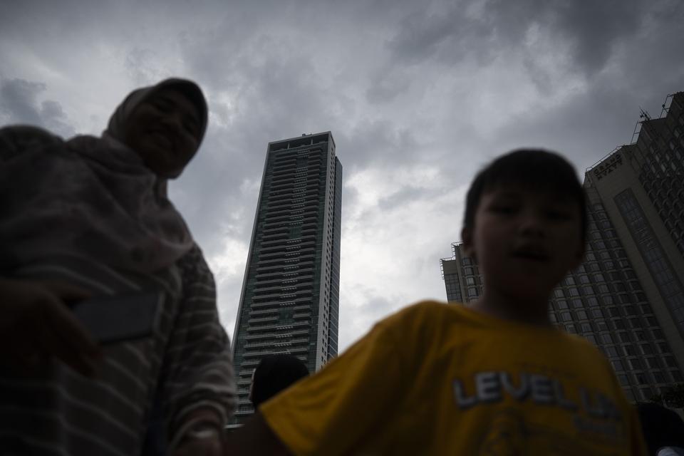 Warga antre untuk berfoto saat awan mendung di Sky Deck Halte Transjakarta Bundaran HI, Jakarta, Kamis (4/7/2024). Badan Meteorologi, Klimatologi, dan Geofisika (BMKG) mengeluarkan peringatan dini cuaca ekstrem seperti hujan lebat disertai petir dan angin