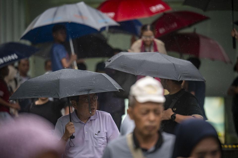 Sejumlah warga menggunakan payung saat turun hujan di kawasan Bundaran HI, Jakarta, Kamis (4/7/2024). 