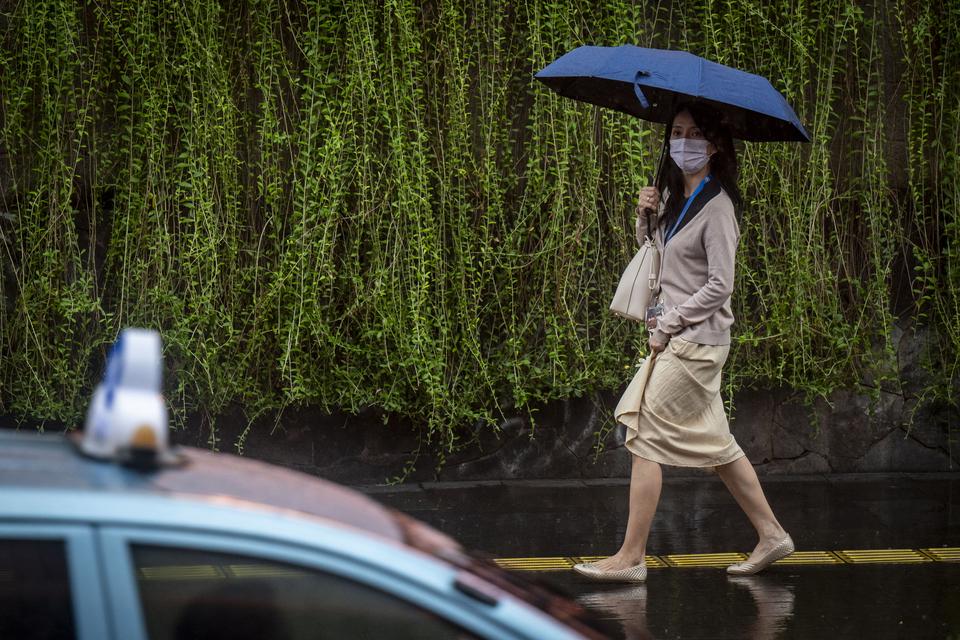 Seorang warga menggunakan payung saat turun hujan di kawasan Bundaran HI, Jakarta, Kamis (4/7/2024).Badan Meteorologi, Klimatologi, dan Geofisika (BMKG) mengeluarkan peringatan dini cuaca ekstrem seperti hujan lebat disertai petir dan angin kencang untuk 