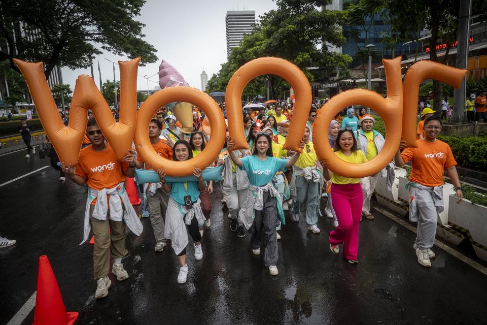 Sejumlah peserta mengikuti fun walk Wondr Parade oleh BNI saat Hari Bebas Kendaraan Bermotor (HBKB) di Jakarta, Minggu (7/7/2024). 