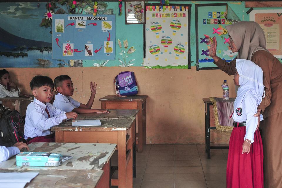 Guru mendampingi siswa di ruang kelas saat mengikuti masa pengenalan lingkungan sekolah di SDN 212 Kota Jambi, Jambi, Senin (15/7/2024). Sekolah yang selama satu semester terakhir terpaksa melakukan kegiatan belajar mengajar di sekolah lain akibat konflik