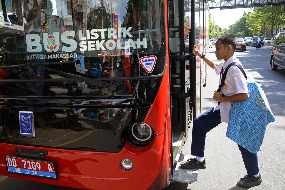 Pelajar SMP Negeri 8 Makassar menaiki bus listrik sekolah yang beroperasi di Jalan Ahmad Yani, Makassar, Sulawesi Selatan, Senin (15/7/2024). 