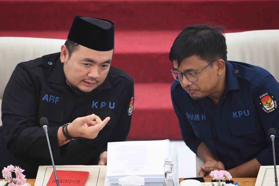 Plt Ketua Komisi Pemilihan Umum (KPU) Mochammad Afifuddin (kiri) dan Komisioner KPU Idham Holik (kanan) berbincang sebelum rapat pleno rekapitulasi nasional Pemilu 2024 pascatindak lanjut putusan Mahkamah Konstitusi (MK) di Gedung KPU, Jakarta, Minggu (28